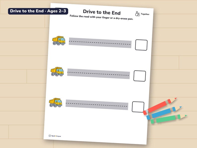 Drive to the End page with straight roads to trace, printed and lying on a wooden table with three crayons.