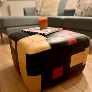 Czarno-czerwony skórzany puf lub podnóżek z lat 70. w stylu patchworkowym — retro, wyrazisty kolor — meble akcentowe w stylu maksimów