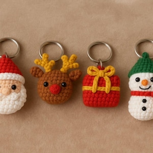 May include: Four crochet Christmas keyrings: Santa Claus, a reindeer, a gift, and a snowman. The Santa has a red hat and white beard. The reindeer has yellow antlers. The gift is red with a yellow bow. The snowman has a green hat and red scarf.