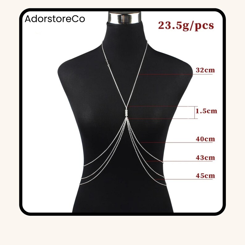 May include: Silver body chain necklace displayed on a mannequin. The necklace features multiple strands and a central design with small beads. Measurements are provided: 32cm, 1.5cm, 40cm, 43cm, and 45cm. The text "AdorstoreCo" and "23.5g/pcs" are visible.