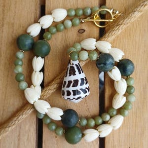 May include: A white ceramic mug with a black handle and the text "But First, Coffee" in a bold, black font. The mug is set against a neutral background, highlighting its simple design.