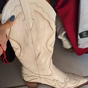 Step into the season with the ultimate statement piece. Our White Vintage Western Boots blend the rugged spirit of the frontier with high-fashion elegance. Featuring intricate tonal embroidery and a sophisticated pointed toe, these knee-high boots are designed to turn heads at weddings, festivals, or on a casual autumn stroll.