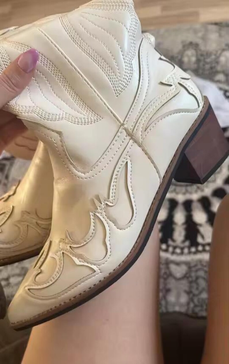 Step into the season with the ultimate statement piece. Our White Vintage Western Boots blend the rugged spirit of the frontier with high-fashion elegance. Featuring intricate tonal embroidery and a sophisticated pointed toe, these knee-high boots are designed to turn heads at weddings, festivals, or on a casual autumn stroll.
