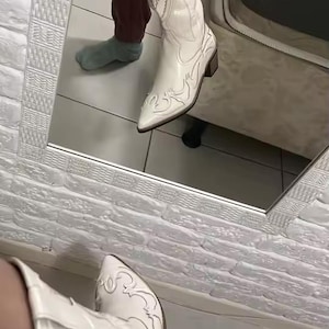Step into the season with the ultimate statement piece. Our White Vintage Western Boots blend the rugged spirit of the frontier with high-fashion elegance. Featuring intricate tonal embroidery and a sophisticated pointed toe, these knee-high boots are designed to turn heads at weddings, festivals, or on a casual autumn stroll.