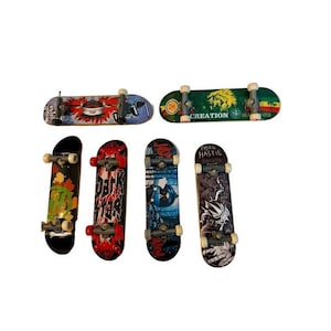 May include: Six finger skateboards with various graphic designs, including a green and yellow board with the text CREATION, a black board with autumn leaves, a red board with the text DARK STAR, and a black board with the text MIKE HASTIE.