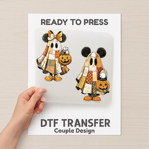 May include: DTF transfer sheet showing two cartoon ghost characters with mouse ears, each holding a jack-o'-lantern. The ghosts wear patchwork outfits in orange, brown, and yellow. Text reads "READY TO PRESS" and "DTF TRANSFER Couple Design".