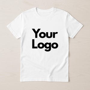 May include: White t-shirt with the text "Your Logo" in bold black letters. The shirt has short sleeves and a crew neck. The design is centered on the front of the shirt.