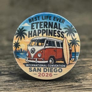May include: A round button with a beach scene featuring a red and white Volkswagen bus, a surfboard, and palm trees. The button has the text "BEST LIFE EVER ETERNAL HAPPINESS INTERNATIONAL CONVENTION SAN DIEGO 2026".