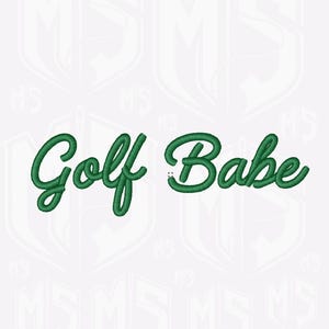 Può includere: Testo ricamato verde su sfondo bianco con la scritta "Golf Babe" in corsivo. Lo sfondo presenta un motivo ripetuto di uno scudo con le lettere "MS" all'interno.