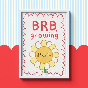 Könnte beinhalten: Gerahmter Druck mit einer fröhlichen Gänseblümchen-Illustration. Die Gänseblümchen hat gelbe Blütenblätter, ein lächelndes Gesicht und einen grünen Stiel. Der Text "BRB, growing" ist rot. Der Hintergrund ist ein gestreiftes Muster in Blau und Weiß.