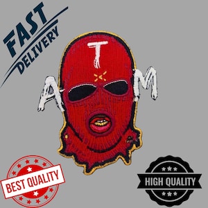 Könnte beinhalten: Ein roter Skimasken-Aufnäher mit den Buchstaben "A" und "M" auf beiden Seiten und einem weißen "T" oben. Der Aufnäher hat einen gelben Rand und ein detailliertes Munddesign. Das Bild enthält auch den Text "FAST DELIVERY", "BEST QUALITY" und "HIGH QUALITY".