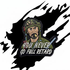 May include: A military-themed patch featuring a cartoon soldier with a cigarette, wearing a camouflage helmet and uniform. The patch has the text "YOU NEVER GO FULL RETARD" in white and yellow lettering.
