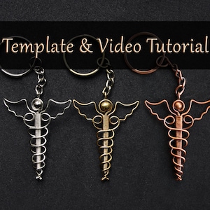 May include: Three silver, gold, and copper wire keychains shaped like the medical symbol, the Rod of Asclepius. The keychains are hanging from their rings.