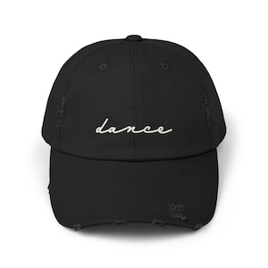 Puede incluir: Gorra de béisbol negra desgastada con la palabra "dance" en escritura blanca en la parte delantera. La gorra tiene una visera curva y un aspecto desgastado, con bordes deshilachados.