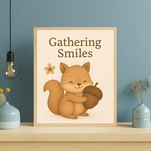 May include: A framed print featuring a cartoon squirrel holding an acorn. The squirrel is brown with a fluffy tail and a smiling face. The print has the words "Gathering Smiles" in brown text, with a small flower graphic.