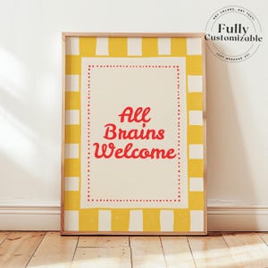 Könnte beinhalten: Ein gerahmter Kunstdruck mit einem gelb-weiß gestreiften Rand. Der cremefarbene Mittelbereich trägt den Text "All Brains Welcome" in roter Schrift. Der Rahmen hat eine helle Holzfarbe. Der Druck wird auf einem Holzboden präsentiert.