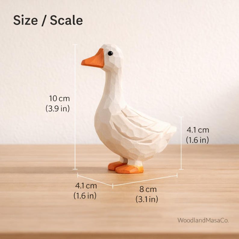 May include: A carved wooden goose figurine with a white body and orange beak and feet. The figure features faceted surfaces and measures 3.9 inches in height, 1.6 inches in width, and 3.1 inches in length. Text reads Size / Scale and WoodlandMasaCo.