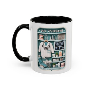 May include: White ceramic mug with a black interior and handle. The mug features a detailed illustration of a dentist's office, including a lab coat, dental tools, and an X-ray. Text on the mug reads "DDS. YOURNAME" and "PROUD TO CREATE HEALTHY SMILES."