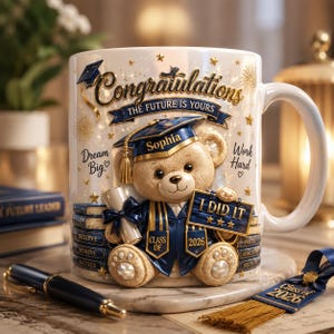 May include: White ceramic graduation mug with a teddy bear in a graduation cap and gown. The mug says "Congratulations" and "The Future is Yours", with "Sophia" on the cap. It also has "I DID IT" and "Class of 2026". The mug is decorated with stars.