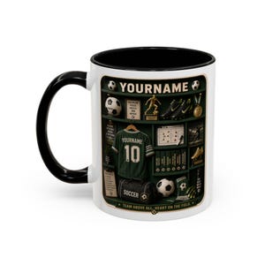 Pode incluir: Caneca de cerâmica branca com alça e interior pretos. A caneca apresenta um design temático de futebol com uma camisa verde, bolas de futebol e o texto "YOURNAME" e "SOCCER".