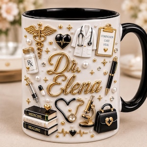 Puede incluir: Una taza de cerámica blanca con asa e interior negros, con iconos médicos en relieve dorados y negros que incluyen un caduceo, estetoscopio, microscopio y libros etiquetados Medicine, Knowledge, Healing. El texto dice Dr. Elena.