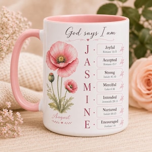 May include: White ceramic mug with a pink handle and interior. The mug features a floral design with pink poppies and the name "Jasmine" in pink letters. Text includes "God says I am" and inspirational words.