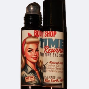 May include: A black and white roll-on bottle with a vintage-style illustration of a woman with blonde hair and red lipstick. The label reads "BODY SHOP TIME Rewind FINE TUNE EYE SKIN" and lists ingredients including castor oil, grape seed oil, and frankincense. The bottle is labeled "USA MADE 10 ML Blue Earth, MN".