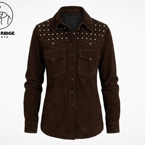 May include: A dark brown suede shirt with long sleeves, two chest pockets, and silver stud embellishments on the shoulders. The shirt has a button-down front and a classic collar. The logo "Retro Ridge Jackets" is in the upper left corner.