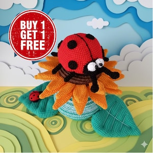 Puede incluir: Una mariquita roja tejida con puntos negros se asienta sobre un girasol tejido con pétalos naranjas y un centro marrón. La mariquita descansa sobre una base azul y verde con hojas verdes. La imagen incluye el texto "BUY 1 GET 1 FREE".