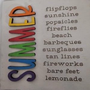 May include: A square white wooden sign featuring the word SUMMER written vertically in large, colorful, raised letters. To the right, the words flipflops, sunshine, popsicles, fireflies, beach, barbeques, sunglasses, tan lines, fireworks, bare feet, lemonade.