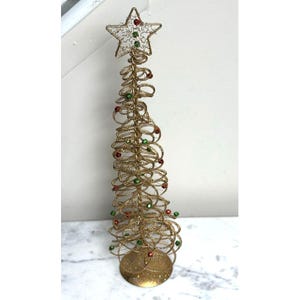 Puede incluir: Un árbol de Navidad de alambre dorado con una estrella en la parte superior. El árbol está decorado con cuentas rojas y verdes. El árbol tiene una base redonda y mide aproximadamente 38 cm de altura.