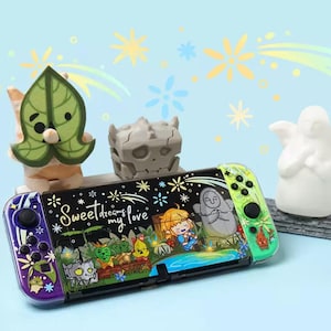 Könnte beinhalten: Ein individueller Nintendo Switch-Controller mit einem schwarzen Mittelteil, der eine farbenfrohe Illustration und den Text "Sweet dreams my love" zeigt. Der Controller hat lila und grüne Akzente. Dekorative Figuren sind im Hintergrund.