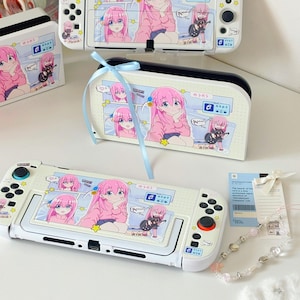 May include: White Nintendo Switch console and accessories featuring a pink-haired anime character design. The image includes a console, a carrying case, and a charging dock, all with matching artwork. A light blue ribbon is tied around the carrying case.
