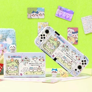 Peut inclure: Une coque de Nintendo Switch bleu clair et une boîte de rangement assortie, toutes deux décorées de personnages de dessins animés, de nuages et d'étoiles. L'étui et la boîte comportent le texte "CHIKAWA" et "it's ok". Plusieurs petites figurines et cartes décoratives sont également visibles.