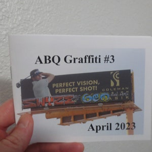 May include: A printed booklet titled "ABQ Graffiti #3" featuring a billboard with graffiti art and the text "PERFECT VISION, PERFECT SHOT!". The booklet also includes the date "April 2023".