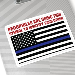 May include: A rectangular sticker featuring a stylised American flag with a single horizontal blue stripe, accompanied by the red text: PEDOPHILES ARE USING THIS SYMBOL TO IDENTIFY EACH OTHER. The sticker is applied to the surface of a grey skateboard deck.