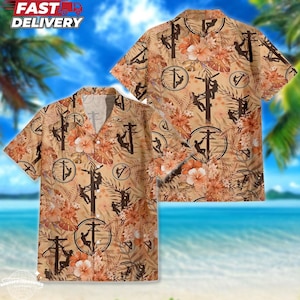 May include: Short-sleeved button-down shirt with a tan background, featuring a repeating pattern of utility pole workers, utility poles, and floral designs in shades of brown, orange, and white. The shirt has a V-neck collar and is displayed against a tropical beach scene.