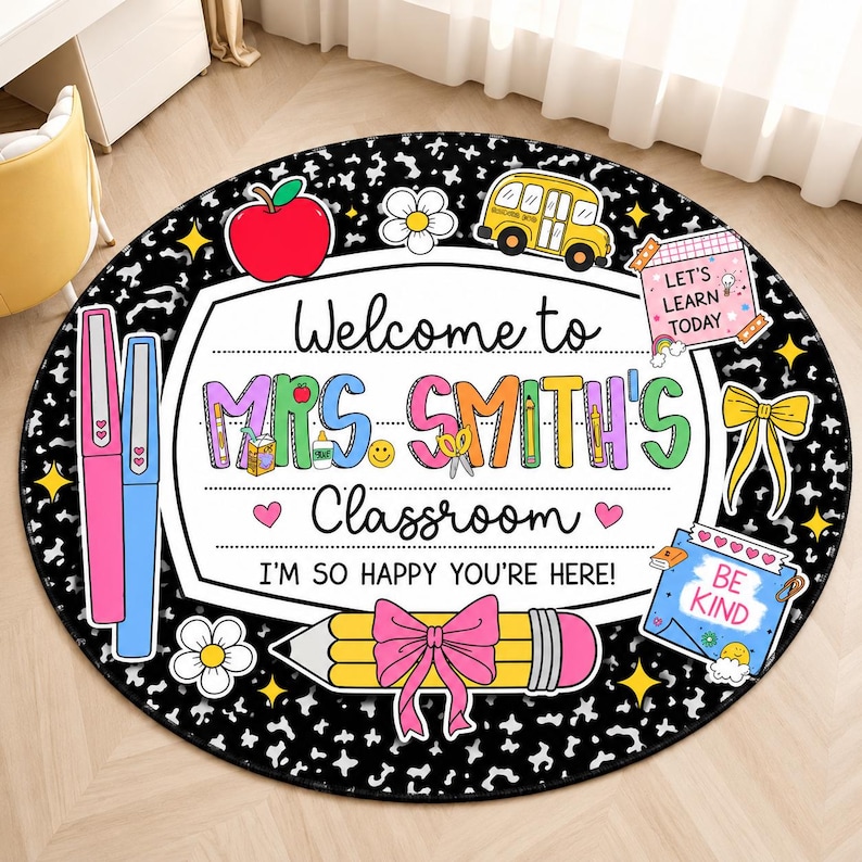 May include: A round classroom rug with a black and white speckled background. The center features a white sign reading Welcome to MRS. SMITH'S Classroom I'M SO HAPPY YOU'RE HERE! Decorated with a red apple, yellow bus, pencil, and notes.