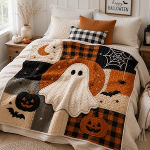 May include: A quilted throw blanket featuring a patchwork design with Halloween motifs including a central white ghost, orange pumpkins, black bats, a spider web, and a crescent moon. The quilt incorporates black and orange plaid fabric patterns.