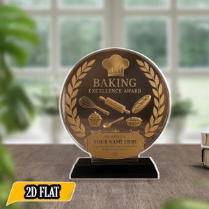 Könnte beinhalten: Auszeichnung für Backkunst aus transparentem Acryl mit schwarzem Sockel. Die Auszeichnung zeigt goldfarbene Symbole von Backwerkzeugen und eine Kochmütze. Der Text "BAKING EXCELLENCE AWARD" steht oben, darunter Platz für einen Namen. Ca. 15 cm hoch.