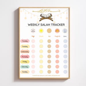 Könnte beinhalten: Ein gerahmter Druck mit dem Text "WEEKLY SALAH TRACKER" und arabischer Schrift oben. Der Tracker enthält Wochentage und Kreise zum Markieren der Gebetszeiten: Fajr, Dhuhr, Asr, Maghrib und Isha. Der Druck hat einen hellen Holzrahmen.