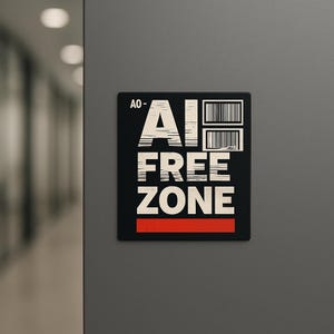 May include: A black square sign with the words "AI FREE ZONE" in large white block letters. The sign also features two barcode graphics and a red horizontal stripe at the bottom. The sign is mounted on a gray wall.