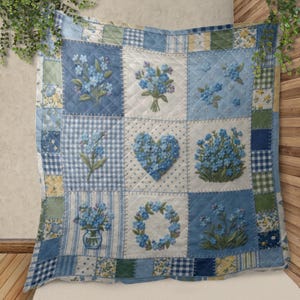 May include: A square patchwork pillow featuring embroidered blue forget-me-nots on a light blue and white background. The pillow has a variety of patterns, including gingham, floral, and solid squares. The overall design is a charming, cottage-style aesthetic.