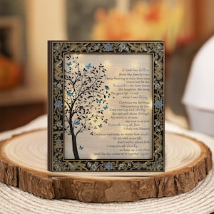 Puede incluir: Una impresión enmarcada con un árbol negro con acentos de mariposas azules y un poema. El marco tiene un borde decorativo dorado y negro. La impresión se muestra sobre una superficie de madera.