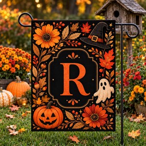 Peut inclure: Un drapeau de jardin rectangulaire sur fond noir avec une lettre R orange centrale dans un cadre décoratif. Le motif comprend des fleurs orange, des feuilles d'automne, un chapeau de sorcière noir, une citrouille souriante et un fantôme blanc.