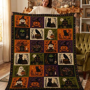 May include: A rectangular Halloween-themed quilt featuring a grid of twenty square panels. Each panel displays illustrations of black cats, ghosts, pumpkins, haunted houses, and ravens, with some panels containing the text Hocus Pocus or Trick or Treat.