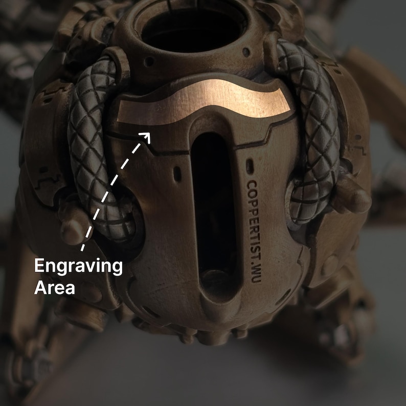 May include: Close-up of a bronze-colored, mechanical-looking object with a copper-colored accent. The text "COPPERTIST.WU" is visible. The image highlights an engraving area.
