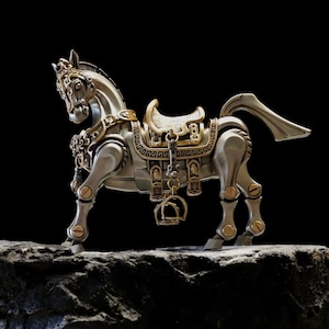 May include: A detailed silver and gold-toned metal horse sculpture with intricate saddle and harness details. The horse is posed on a rocky surface against a black background, showcasing its mechanical design and craftsmanship.
