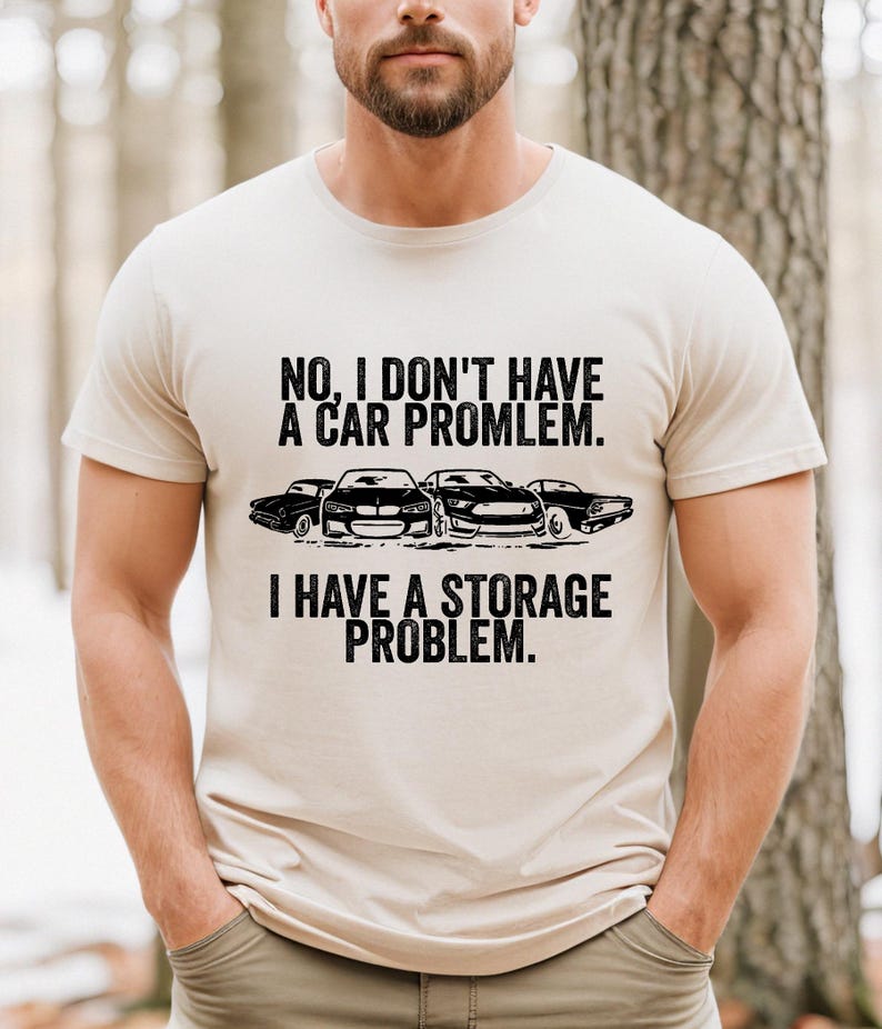 May include: Beige t-shirt with the text "NO, I DON'T HAVE A CAR PROBLEM. I HAVE A STORAGE PROBLEM." in black. Below the text are four black car silhouettes.