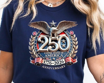 May include: Navy blue t-shirt featuring a patriotic design celebrating the 250th anniversary of the United States of America. The graphic includes an eagle, stars, and the years 1776-2026, with the text "250 United States of America Anniversary."